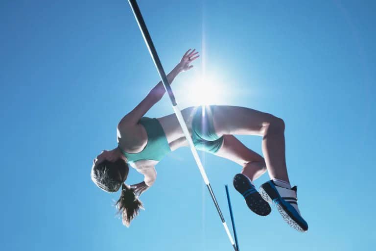 “Persona superando un salto alto, símbolo de desafío y superación”.